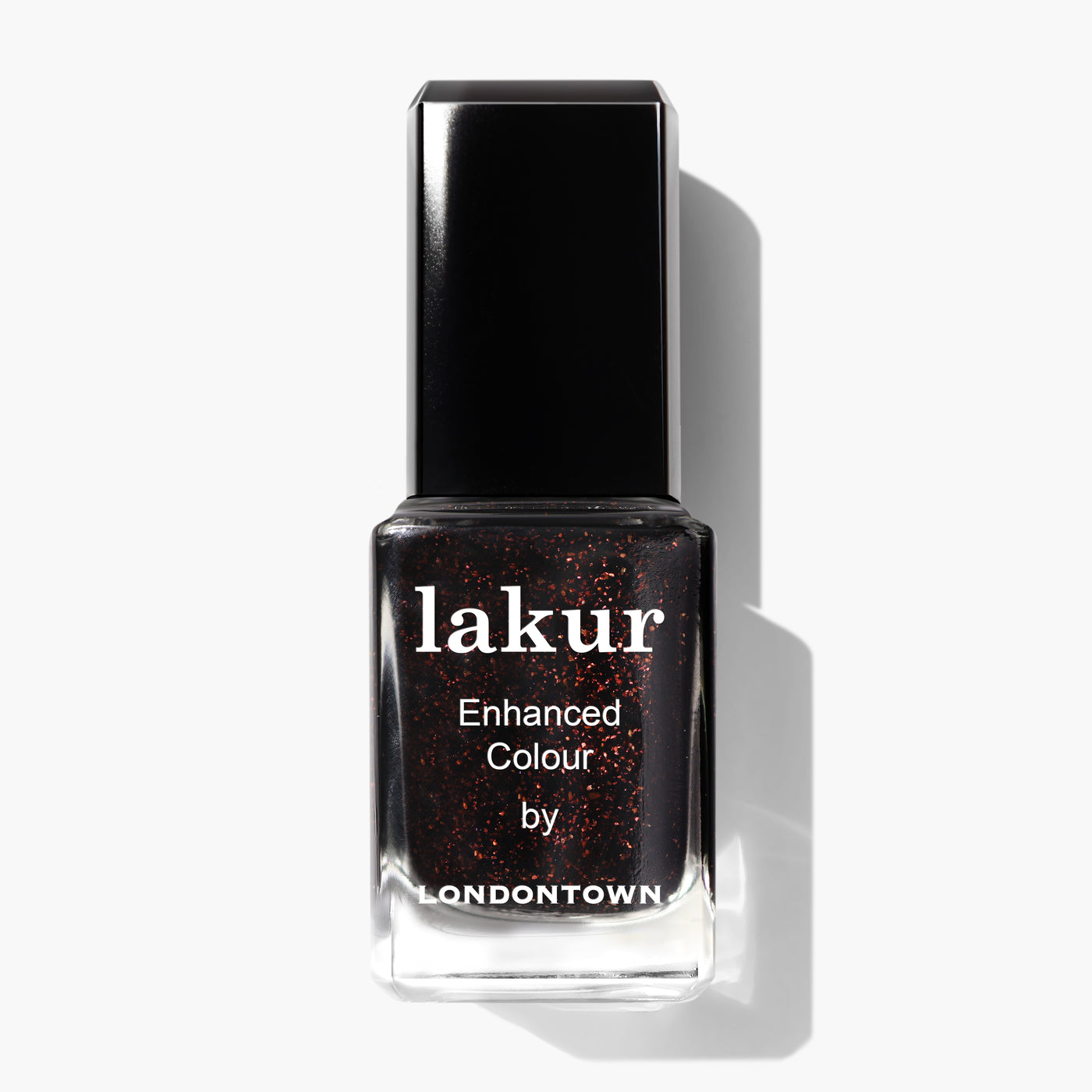 A bottle of "Around the Fireplace" nail polish by LONDONTOWN in deep black with copper-flecked red glitter, featuring the text "lakur Enhanced Colour by LONDONTOWN" on the front.