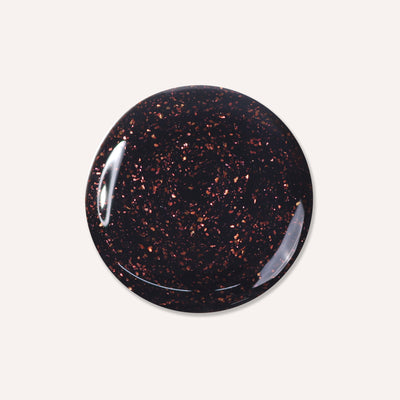 Round, glossy black surface with deep copper-flecked particles scattered throughout, courtesy of "Around the Fireplace" by LONDONTOWN.