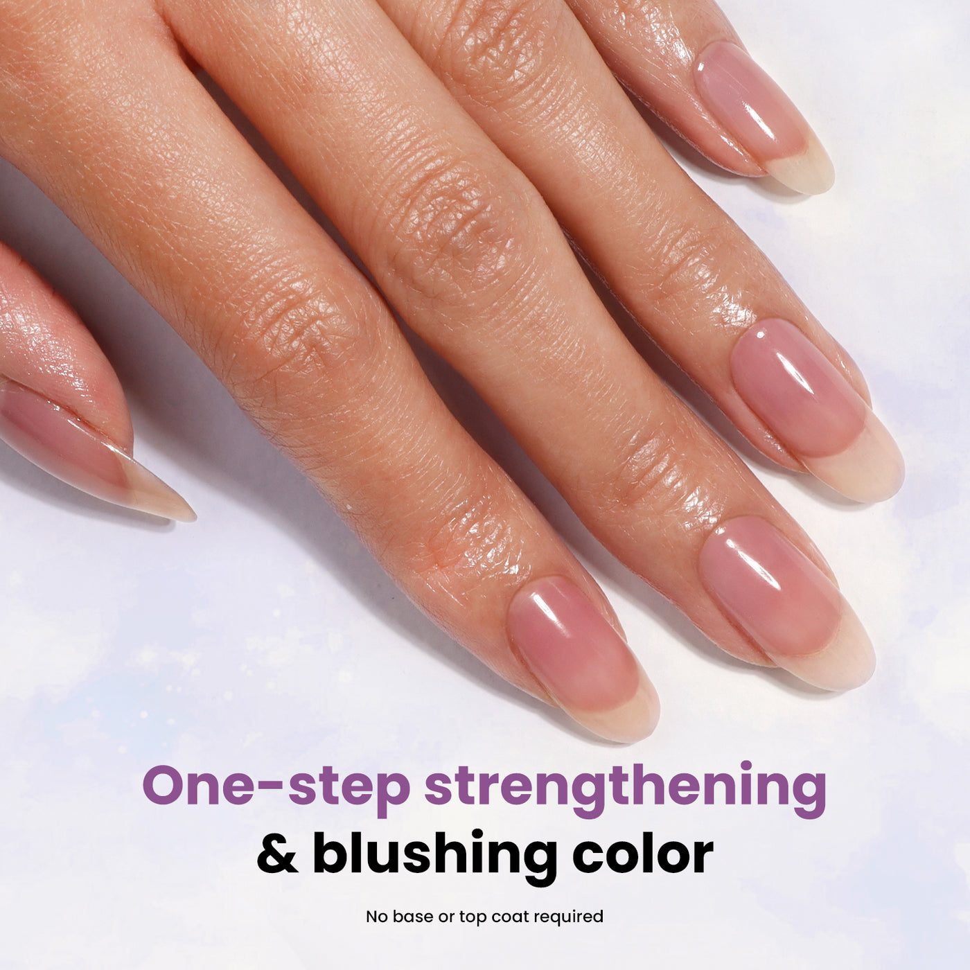 A hand with manicured nails displaying LONDONTOWN's Sheer Strength Nail Blush in the shade Concord, a pink, high-gloss nail polish. Text below reads: "One-step strengthening & blushing color with nail hardener. No base or top coat required.