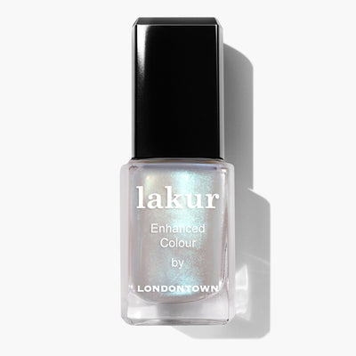 A "Moonstone Chrome" nail polish by LONDONTOWN with an iridescent white hue and a crème-to-chrome finish, features a sleek black cap casting a soft shadow on the pristine white background.