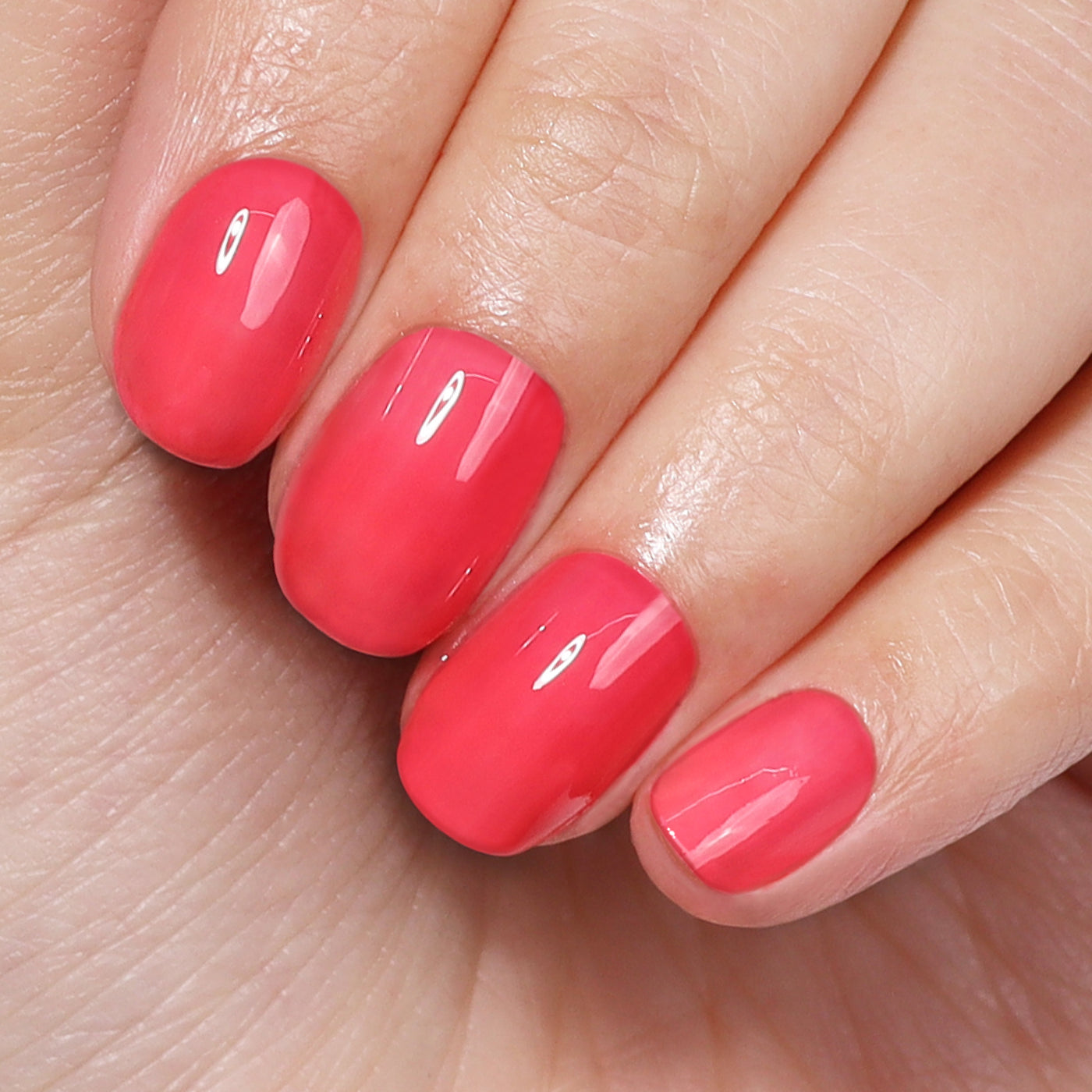 Close-up of four well-manicured fingernails painted with a glossy, power-packed bright pink shade from the Perfecting Nail Veil #8 (Professional) by LONDONTOWN. The nails, showcasing a hint of color, are held against a palm background.