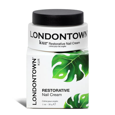 A jar of LONDONTOWN Restorative Nail Cream (Professional), renowned for its transformative moisturizer, rests on its box decorated with the brand name, product name, and images of green leaves. Perfect for rejuvenating dry nails.