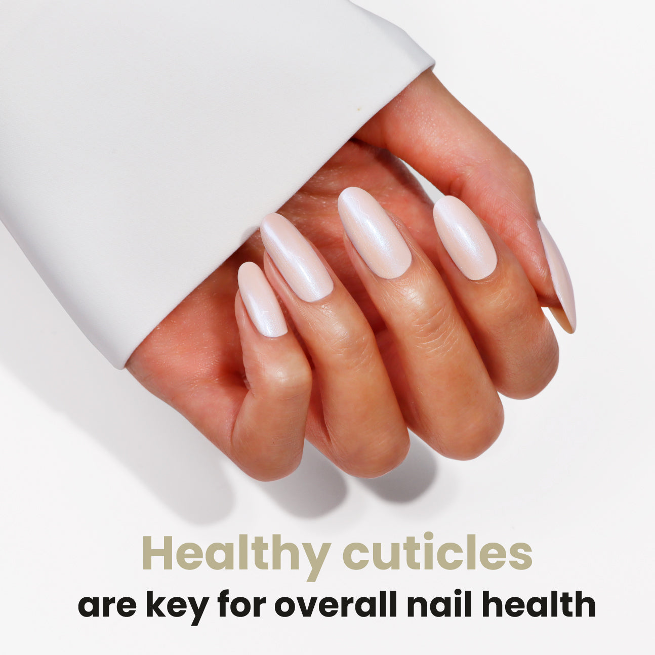 A hand with long, white, glossy nails is displayed, emphasizing the significance of healthy cuticles for overall nail health. Elevate your routine with LONDONTOWN's Nourishing Cuticle Oil to support nail restoration and keep that ideal shine.