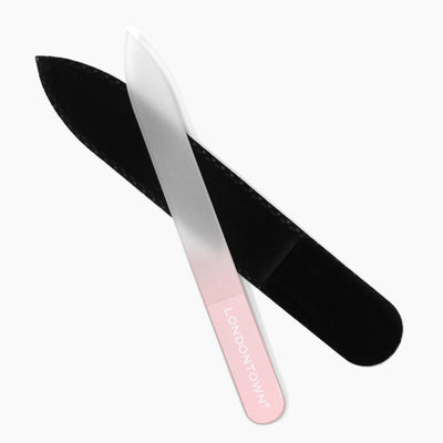 A professional glass nail file labeled "LONDONTOWN" with a pink handle, designed for effortless nail filing and to prevent damage, is laid next to its black protective case on a white background.