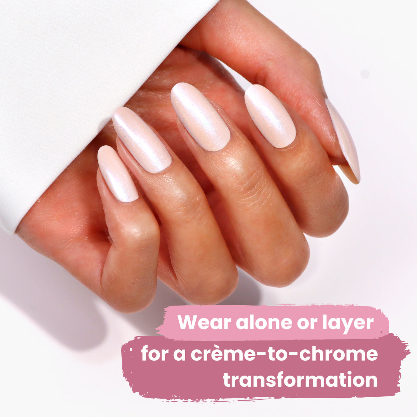 Close-up of a hand with long, almond-shaped nails painted in a pearlescent white color. Text on the image reads: "Wear Pixi Chrome by LONDONTOWN alone or layer for a crème-to-chrome lakur finish.