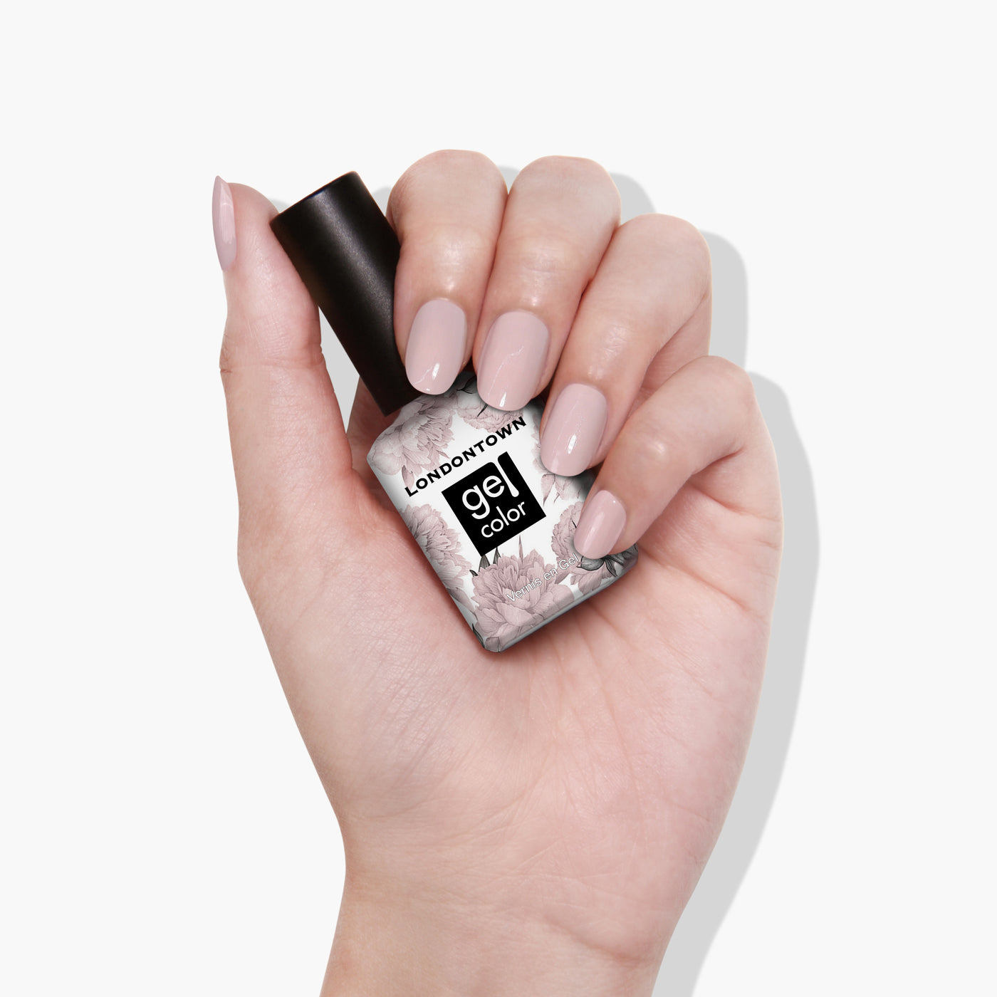 A hand displays a bottle of LONDONTOWN's "Off the Record" gel nail polish, with neatly manicured nails painted in a cool pastel pink shade.