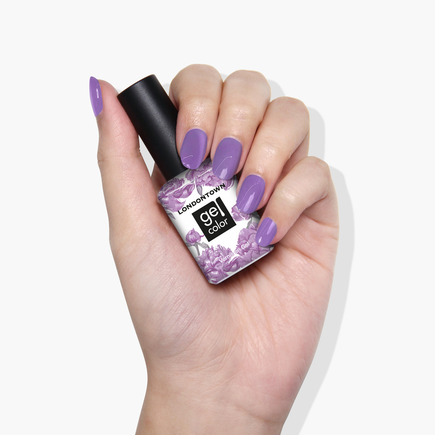 A hand with neatly manicured nails painted in a psychedelic lavender holds a bottle of LONDONTOWN's Road Trip gel nail color in the same shade.