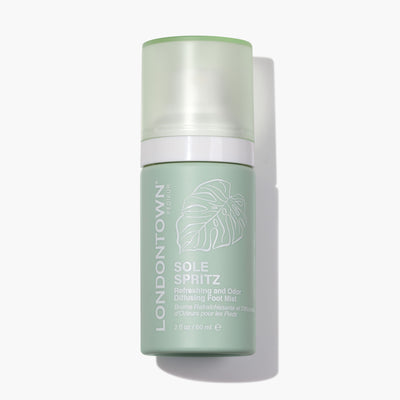 Green bottle of Sole Spritz Foot Mist by LONDONTOWN, 2 fl oz (60 ml), featuring a leaf design on the label, ensures fresh feet with every spritz.