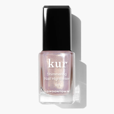 A bottle of LONDONTOWN's Shimmering Nail Highlighter - Sunkissed catches the light with every movement. The clear bottle, topped with a sleek black cap, holds a light, shimmery nail polish that acts as a shimmering shield for your nails.