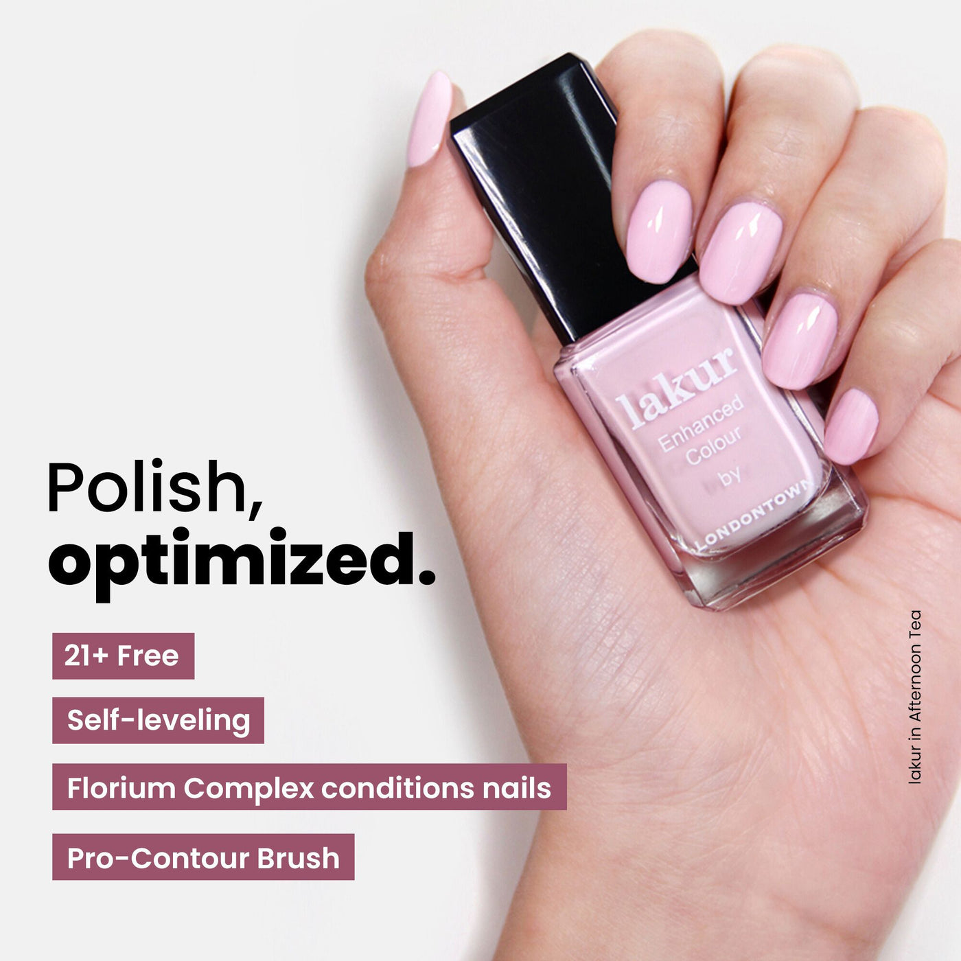 A hand holds a bottle of light pink nail polish from the LONDONTOWN Most-Loved & Must-Haves Set, an essential addition to your perfect wardrobe. With over 21 free benefits, its self-leveling formula with Florium Complex conditions nails, while the Pro-Contour Brush ensures precision—making it an ideal choice for ultimate nail care this holiday season.