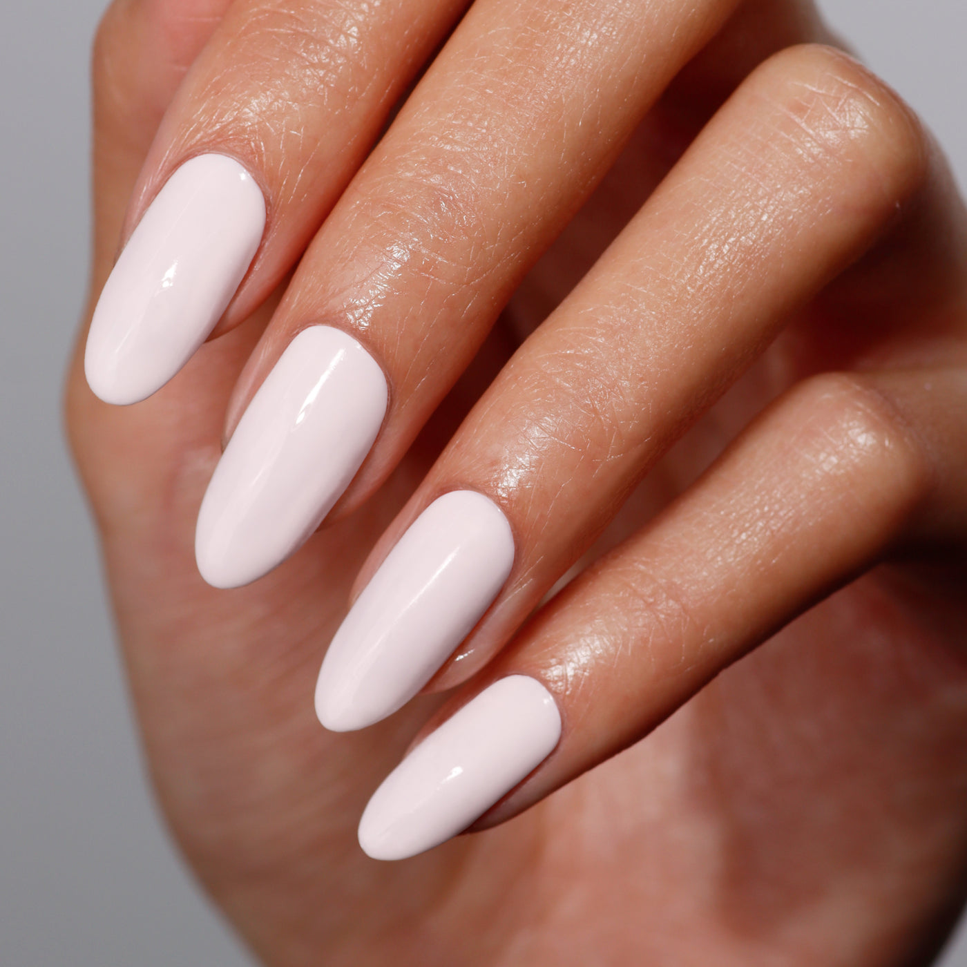 A hand with neatly manicured long nails, painted in the smooth, glossy "Macaroon at Noon" powder pink by LONDONTOWN, exudes a delicate charm.