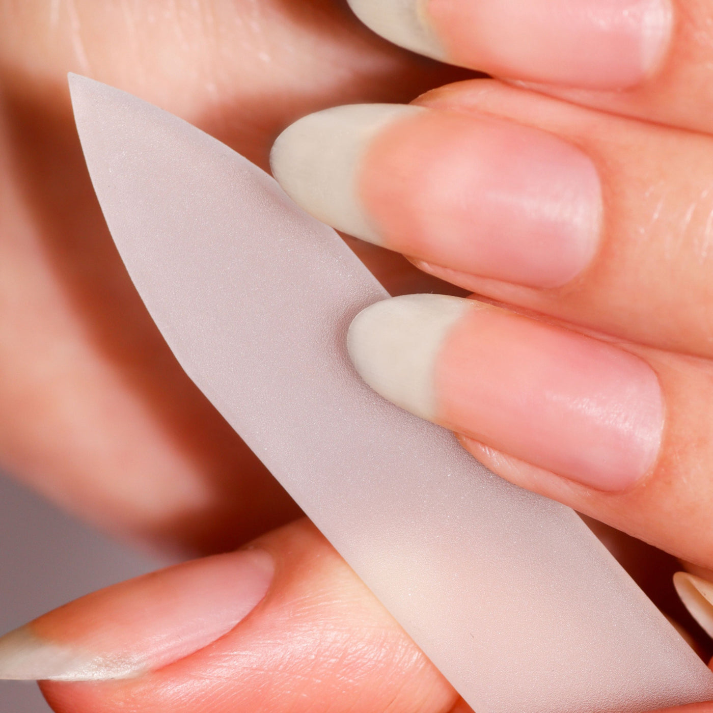 A close-up shows a person using LONDONTOWN's Mini Nail File Set to shape long, natural fingernails, achieving a perfectly filed look.