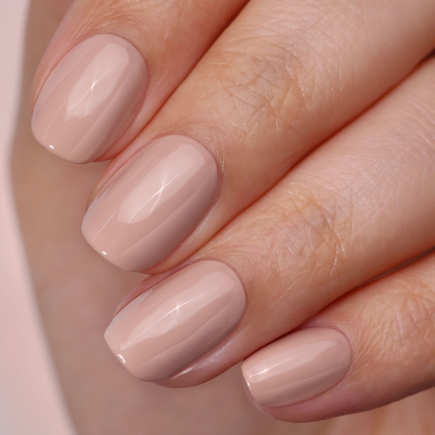 Close-up of a hand with manicured nails in LONDONTOWN's High Gloss Top Coat, showcasing a radiant shiny finish.