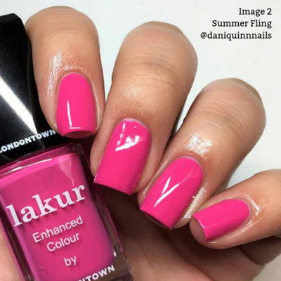 A hand with shocking pink nails delicately holds a bottle of LONDONTOWN's "Summer Fling (Professional)," showcasing its vibrant, vegan, and cruelty-free formula.