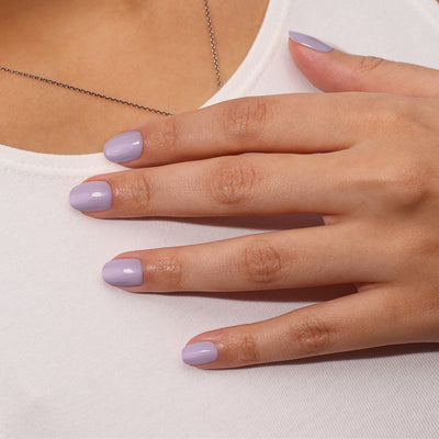 A close-up shows a hand with LONDONTOWN's Honey Lavender nail polish gently resting on a white shirt.