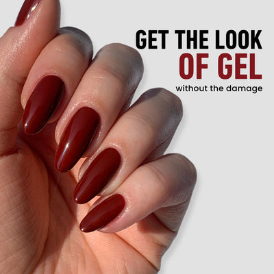 Close-up of a hand with long, dark red nails. Text on the image says "Achieve the gel-like mani look without damage using LONDONTOWN's Gel Genius Top Coat.