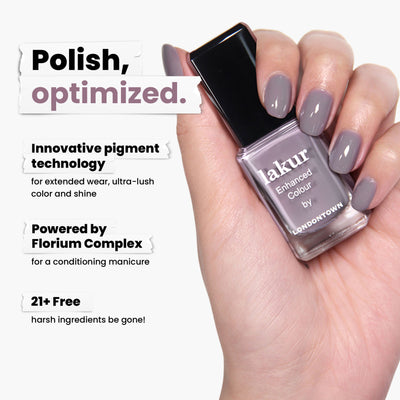 A hand holds a LONDONTOWN Cashmere nail polish bottle, showcasing elegant gray nails. Featuring innovative pigment and powered by Florium Complex, this cruelty-free polish is vegan and free of 21+ harsh ingredients, ensuring your manicure is both kind and stylish.