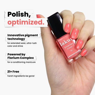 A hand holds a bottle of LONDONTOWN's "Papaya" pink nail polish, labeled "lakur Enhanced Colour." It features innovative pigment technology and is free from 21+ harsh ingredients. This vegan, cruelty-free polish offers rapid drying for a perfect creamy coral finish.