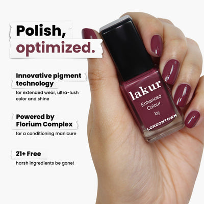 A hand holds a bottle of LONDONTOWN's Fig Jam nail polish, showcasing its captivating mauve-tinged purple. The formula uses innovative pigment technology and Florium Complex, offering a 21+ free formula that enriches your nails without harsh ingredients.