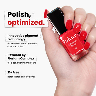 A hand holds a bottle of LONDONTOWN's Londoner Love (Professional) red crème polish, featuring innovative pigment technology and Florium Complex. It is vegan, cruelty-free, and free of 21+ harsh ingredients for a bold look without compromise.