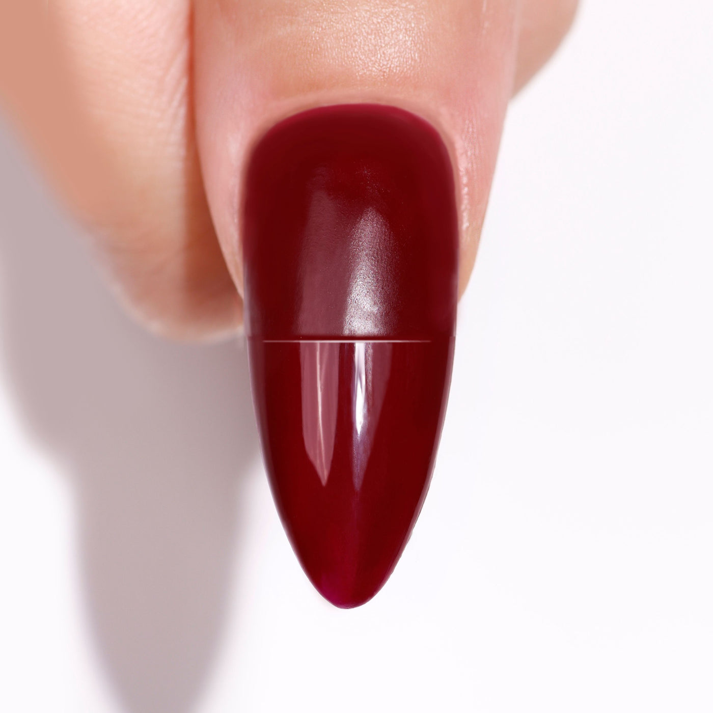 Close-up of a fingernail with LONDONTOWN's Flash Dry Top Coat, featuring glossy dark red polish and a smooth almond shape that boasts a quick-dry finish.