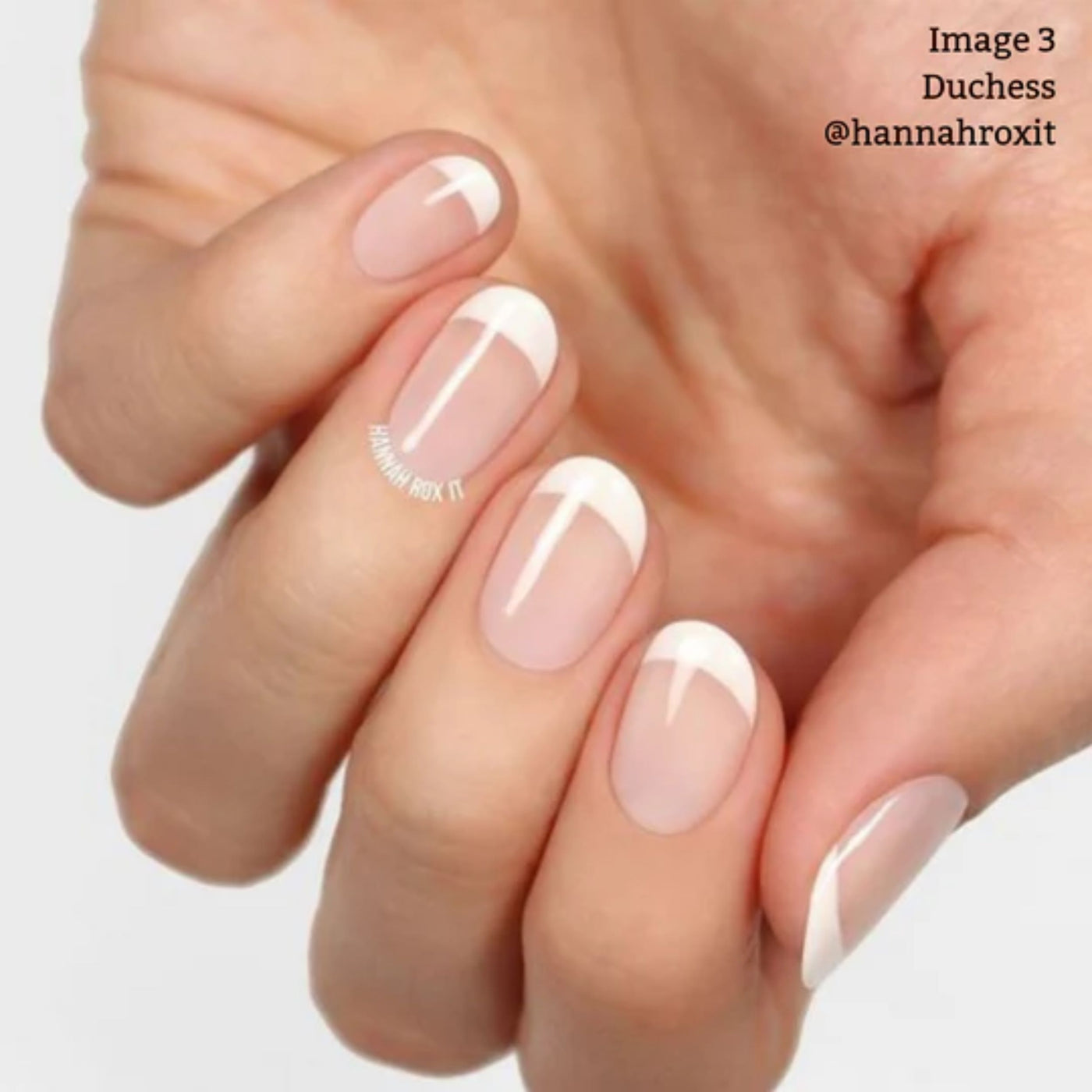 Nails with the Duchess natural French manicure by LONDONTOWN display curved crème white tips and translucent pink bases, all made with vegan, cruelty-free products against a light background.