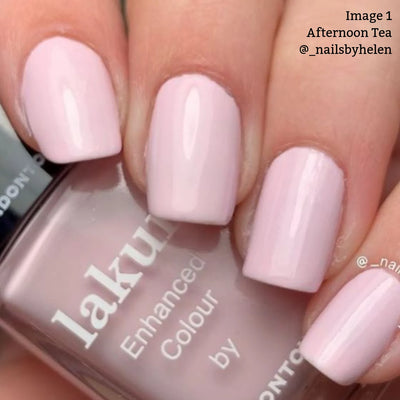 A close-up of a hand with light pink crème manicured nails holding a bottle of LONDONTOWN Lakur Enhanced Colour nail polish in the shade Afternoon Tea (Professional).