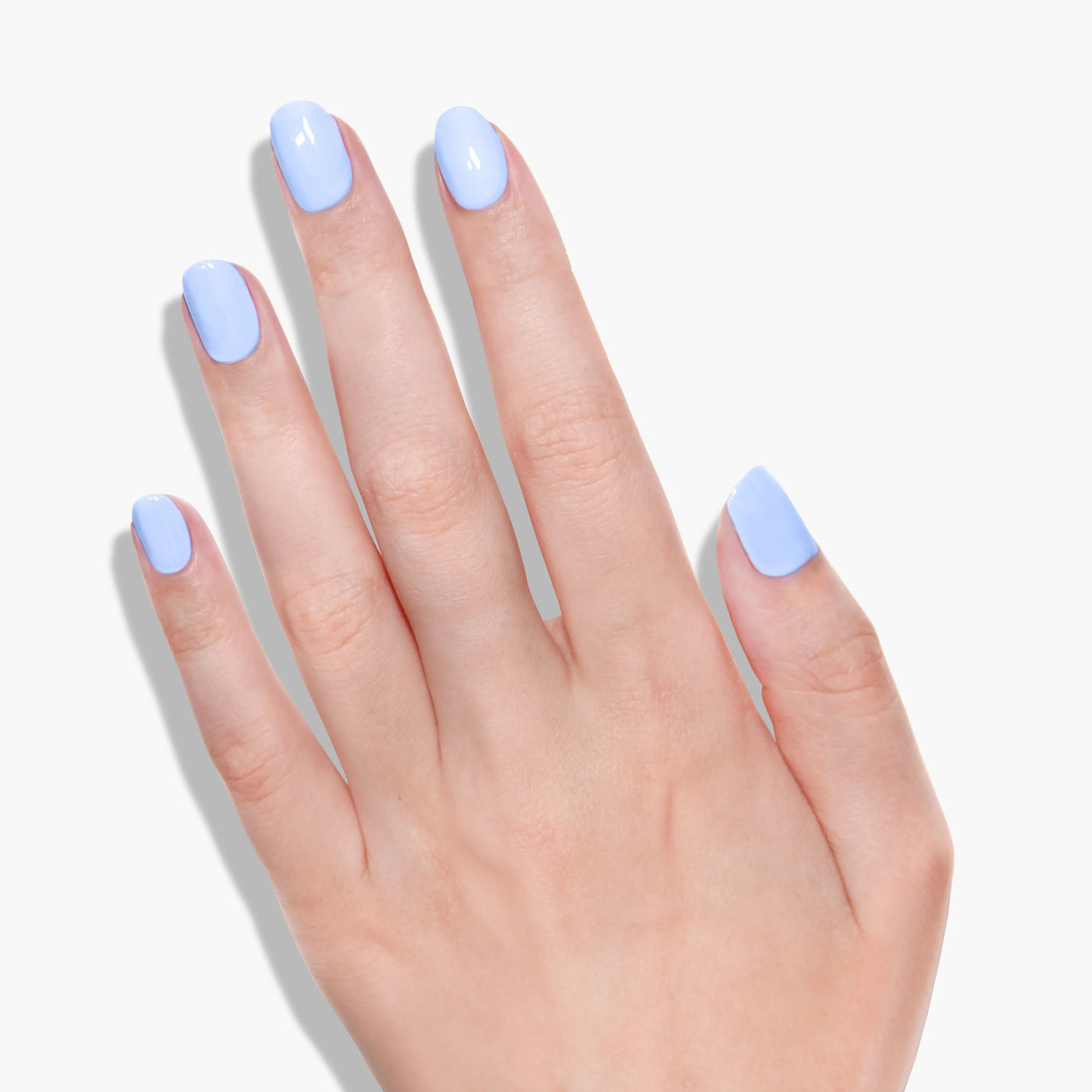 A hand with nails painted in LONDONTOWN's Amalfi Love (Professional), a light blue, vegan, and cruelty-free polish, is displayed against a plain white background.